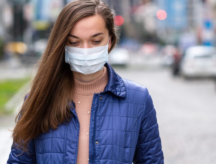Woman in medical mask on street. Protection against virus, infec